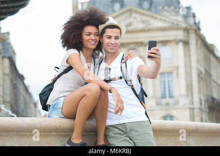 Immagine che mostra la coppia giovane tenendo selfie nella città Foto Stock