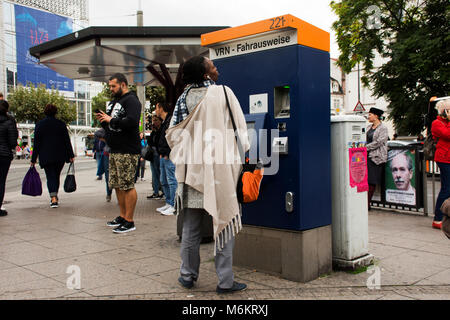 African-German donna Acquista biglietto di tranway dalla vendita automatica ticket box a Heidelberg altstadt o città vecchia stazione su settembre 8, 2017 in Heidelber Foto Stock