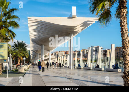 Malaga, Spagna - 7 Dicembre 2016: Le persone sono a piedi lungo il terrapieno (Paseo Del Muelle Dos Promenade) che si estende attraverso la porta sotto un constr Foto Stock