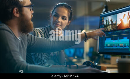 Maschi e femmine di editor video lavorare con filmati e audio sul proprio Personal Computer con due schermi. Sono belli e le persone creative Foto Stock