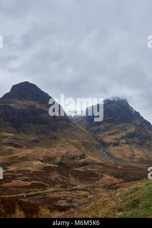 Due delle tre sorelle al Glen Coe su uno scozzese Giornata di Primavera in aprile. Le nuvole basse e nebbia scozzese dramma si prestano alla scena. Foto Stock