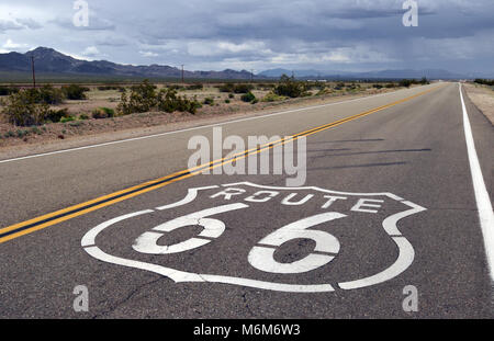 Route 66 scudo dipinto su un tratto di strada deserta vicino al Deserto Mojave comunità di Amboy, California. Foto Stock