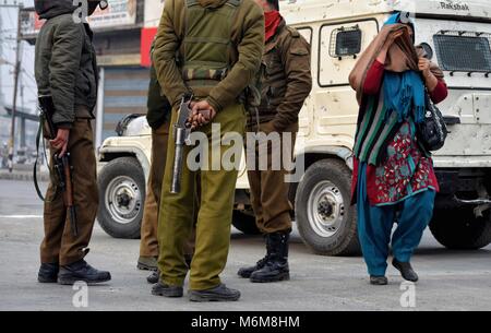 Srinagar, India. Xvi Dec, 2016. Una donna del Kashmir nascondendo il suo viso mentre passa attraverso il gruppo di poliziotti indiani amid coprifuoco simili restrizioni imposte dalle autorità per impedire alla gente di holding JRL-chiamato proteste in area del centro cittadino di Srinagar, la capitale estiva della controllata indiana del Kashmir. Resistenza comune Leadership (JRL) comprendente Syed Ali Shah Geelani, Mirwaiz Umar Farooq e Mohammad Yasin Malik aveva chiamato per la chiusura il lunedì contro le uccisioni Shopian. Credito: Bilal Ahmad/Pacific Press/Alamy Live News Foto Stock