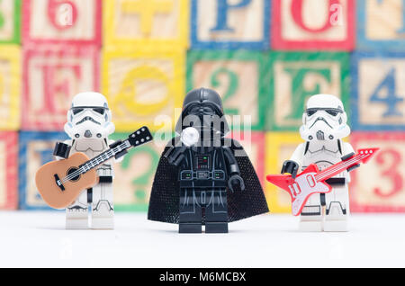 Lego Darth Vader tenendo il microfono con storm troopers tenendo la chitarra isolato su sfondo bianco. Foto Stock