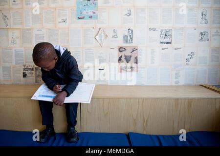 Scuola ragazzo lettura in classe Foto Stock