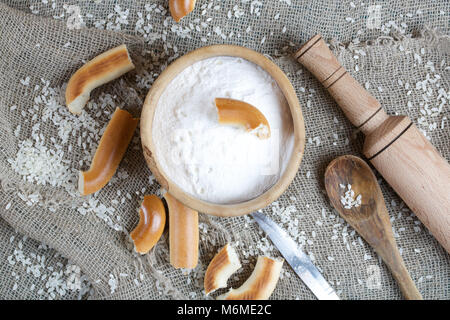 Farina di riso in un legno d'ulivo piastra su un sacco. Foto Stock