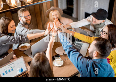 I colleghi dando un cinque in ambienti interni Foto Stock