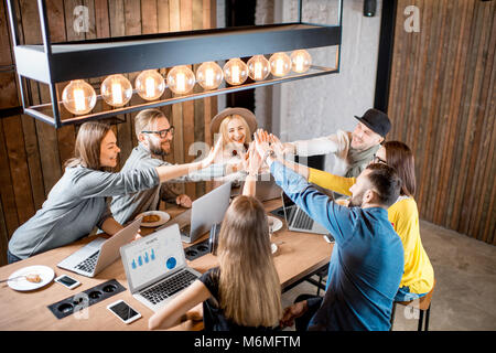 I colleghi dando un cinque in ambienti interni Foto Stock