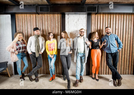Persone in piedi sulla parete in legno per interni di sfondo Foto Stock