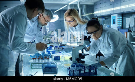 Team di Ricerca Medica scienziati collettivamente lavorando su una nuova generazione di farmaco sperimentale di trattamento. Guarda laboratorio occupato, luminoso e moderno. Foto Stock