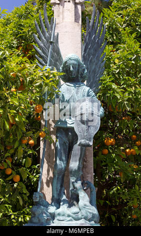 Statua di bronzo di un angelo guerriero contro un albero da frutto in Valencia, Spagna Foto Stock