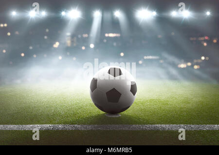 Black Football su un campo sportivo vuoto illuminato di notte  retroilluminato da luci luminose in una vista ad angolo basso con ombra,  nebbia e spazio di copia Foto stock - Alamy