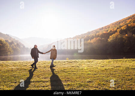 Coppia senior in una passeggiata in un autunno natura. Foto Stock