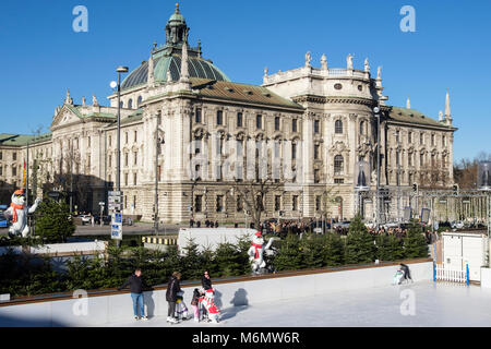 Persone pattino da ghiaccio su un pubblico pista di pattinaggio su ghiaccio con Justizpalast MONACO Palazzo di Giustizia dietro. Stachus Karlsplatz, Monaco di Baviera, Germania, Europa Foto Stock