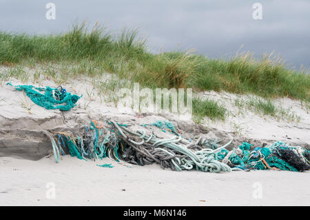 La pesca di funi e reti scartato e aggrovigliato in la spiaggia e le dune di sabbia sulla spiaggia Howmore, Sud Uist, Ebridi Esterne, Scotland, Regno Unito Foto Stock