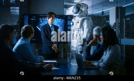 Nella Sala Conferenze del Centro di tecnologia Chief Engineer presenta la prossima generazione tuta spaziale ad un consiglio di amministrazione. Foto Stock