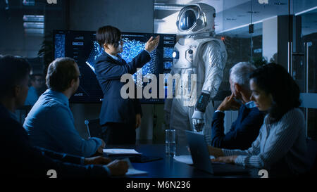 Nella Sala Conferenze del Centro di tecnologia Chief Engineer presenta la prossima generazione tuta spaziale ad un consiglio di amministrazione. Foto Stock