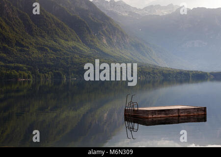 Panorama del Lago glaciale di Bohinj con legno zattera nuotare con scaletta galleggiante su un lago, il Parco Nazionale del Triglav, sulle Alpi Giulie, Gorenjska, Slovenia Foto Stock