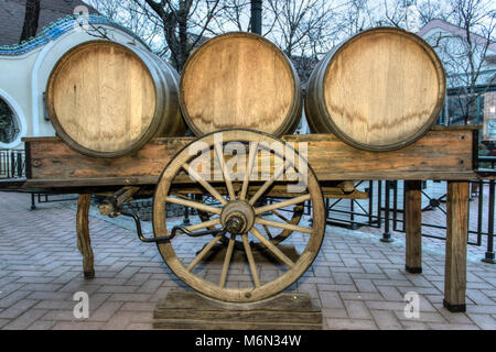 Subotica, Vojvodina, Serbia - botti da vino su un carrello in un cortile pavimentato Foto Stock