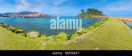 Panorama di Lekeitio villaggio con San Nicolas isola e pier con moss Foto Stock