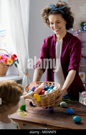 Giovane donna dando le uova di Pasqua Foto Stock