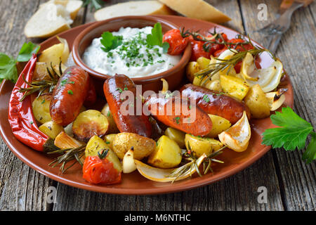 Cena spagnola: caldo cotto il chorizo salsicce con rosmarino verdure ed erbe mediterranee cagliata Foto Stock