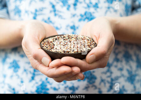 Close up della donna azienda tazza di quinoa Foto Stock