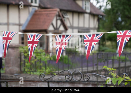 Unione Jack bunting al di fuori del tradizionale casa britannica Foto Stock