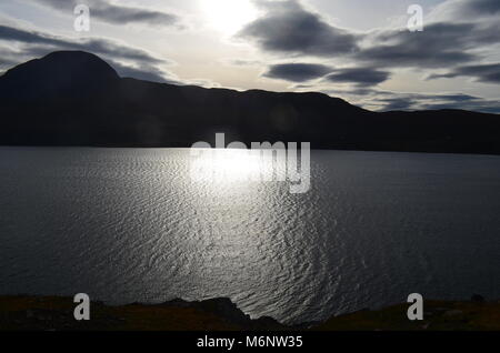 Sun riflettendo sul piccolo Loch Ginestra Foto Stock
