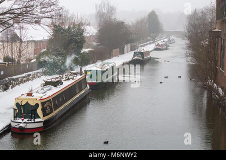 Battelli, chiatte, strette barche coperte di neve sul canale di Coventry, vicino a Atherstone, Warwickshire Foto Stock