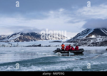 G expedition cruise passeggeri in un gommone Zodiac guardando per guarnizioni di tenuta e di fauna selvatica sul mare di ghiaccio off isola Spitsbergen, Svalbard, Norvegia, Scandinavia, UE Foto Stock