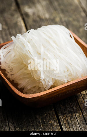 Secchi spaghetti di riso su un tavolo di legno. Foto Stock