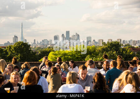 I giovani di socializzare e gustare un drink insieme a Franchi outdoor cafe bar sul tetto e ristorante in Peckham, Londra del sud con vista della città. Foto Stock