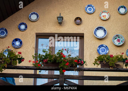 Il balcone di una casa decorata con diversi piatti Foto Stock