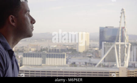 Giovane uomo d affari tourist guardando fuori Las Vegas hotel casino resort la finestra si affaccia sul skyline durante il giorno Foto Stock