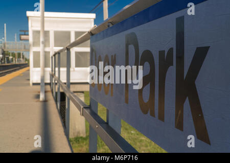 Long Island, NY - Circa 2017: Deer Park LIRR ferrovia stazione ferroviaria segno sulla piattaforma. La mattina presto il giorno. Traccia vuota nessun popolo Foto Stock