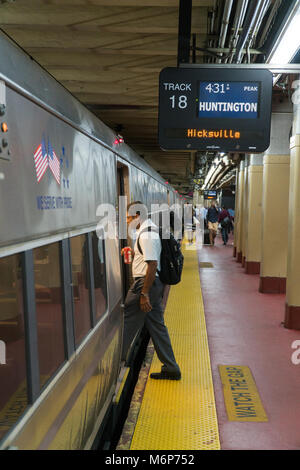 La città di New York, circa 2017: Passeggeri immettere Long Island Railroad LIRR treno a Penn Station terminal di Manhattan. Treni pendolari a casa durante le ore di punta Foto Stock