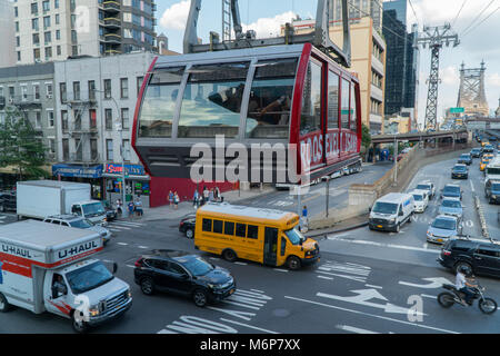 La città di New York, circa 2017: Roosevelt Island Tram attraversa sopra il traffico intenso in Manhattan durante il giorno Foto Stock