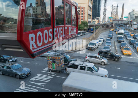 La città di New York, circa 2017: Roosevelt Island Tram attraversa sopra il traffico intenso in Manhattan durante il giorno Foto Stock