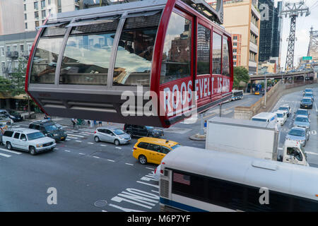 La città di New York, circa 2017: Roosevelt Island Tram attraversa sopra il traffico intenso in Manhattan durante il giorno Foto Stock