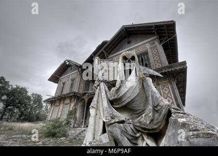Haunted House con un gream reaper statua in primo piano Foto Stock