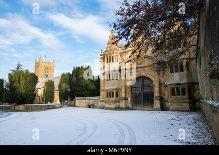 Stanway casa gatehouse e Chiesa di San Pietro nella neve d'inverno. Stanway, Cotswolds, Worcestershire, Inghilterra Foto Stock