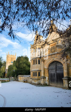 Stanway casa gatehouse e Chiesa di San Pietro nella neve d'inverno. Stanway, Cotswolds, Worcestershire, Inghilterra Foto Stock