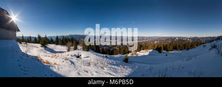 Ampio paesaggio panoramico dal vertice nevoso di montagna Rennfeld con capanna e le lontane cime di montagna in inverno Foto Stock