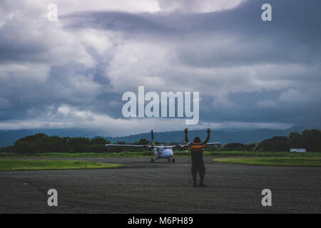 Il controllo del traffico aereo a dirigere una Twin Otter nella baia di arrivo all aeroporto di Honiara Foto Stock