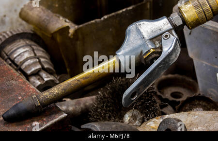 Vintage antica macchina automotive shop compressore aria ugello flessibile con un collo in ottone e punta di gomma in un cassetto pieno di vecchi attrezzi sporchi Foto Stock