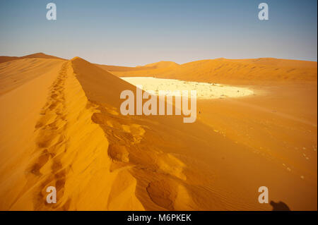 Duna Rossa sul Namib Naukluft National Park, nell'area di Sossusvlei. Dead Vlei può essere visto come un bianco marchio rotondo sulla destra, Namibia Foto Stock