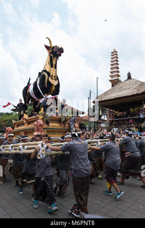 Uomini Balinese il trasporto pesante sarcofago nero Bull attraverso le strade di Ubud, Bali per la cerimonia di cremazione della regina Niang Agung Foto Stock