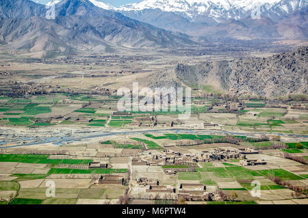 Foto aerea di piccoli villaggi tra Kabul e Ghazni in Afghanistan con campi agricoli, montagne e un fiume in una valle Foto Stock