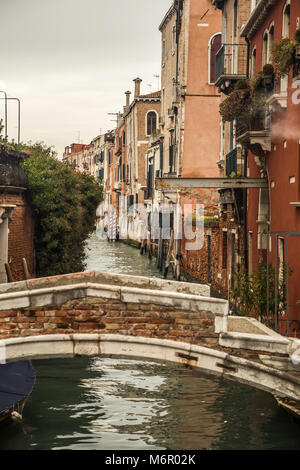 Piccoli romantici canali e corridoi stretti con picchi di casa durante il tramonto, Venezia, Italia Foto Stock